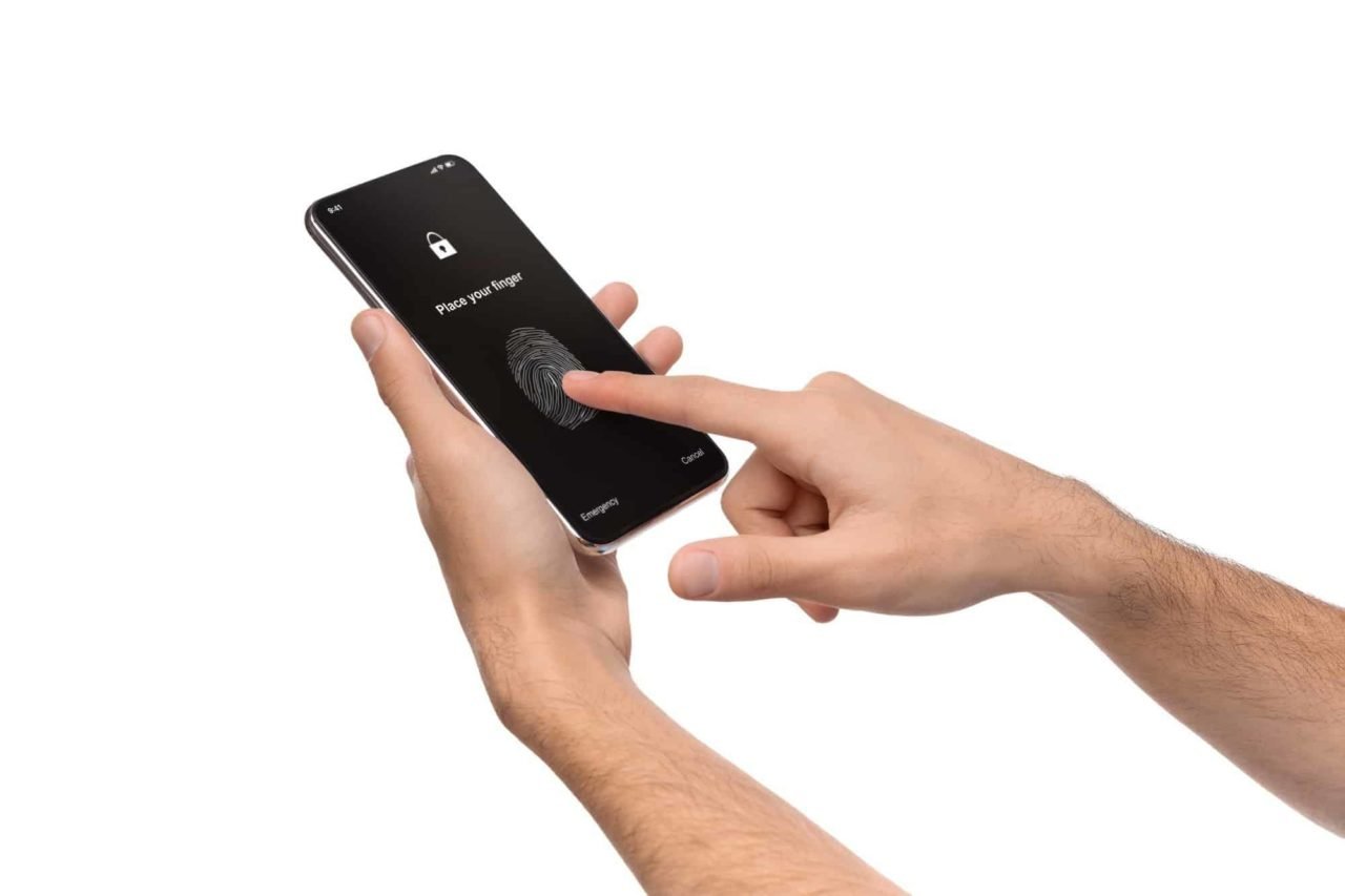 Man's hands using fingerprint scanning app on cellphone screen