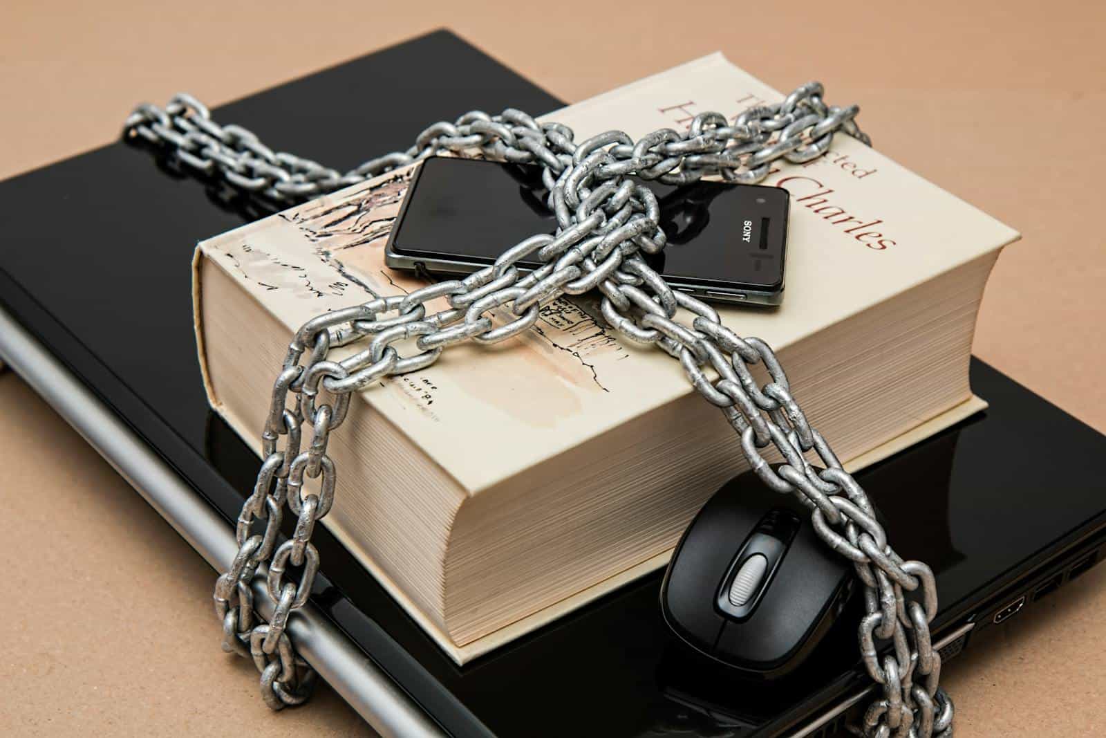 Password, Chain-locked book, phone, and laptop symbolizing digital and intellectual security.