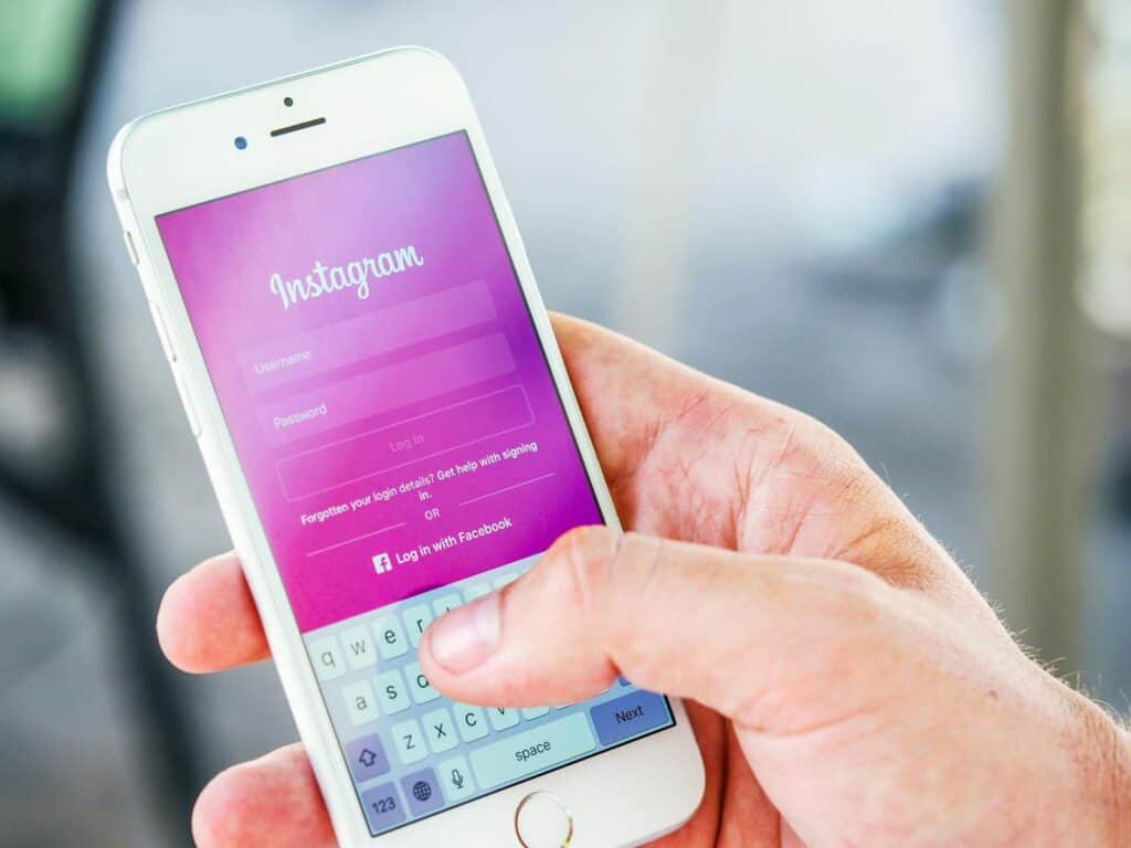 Instagram, Marketing, Close-up of a hand holding a smartphone displaying the Instagram login screen, highlighting mobile technology.