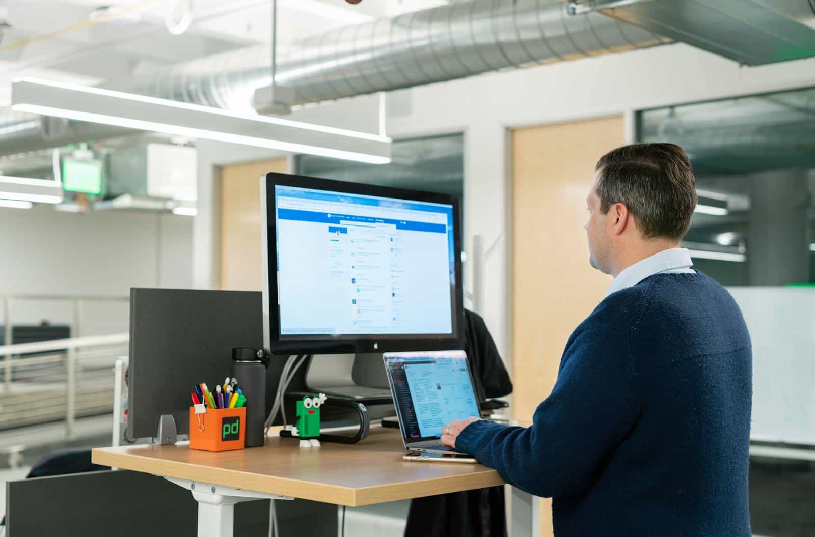 LinkedIn, Marketing, Man working at standing desk on laptop in a modern office setting, focusing on LinkedIn sales tools.