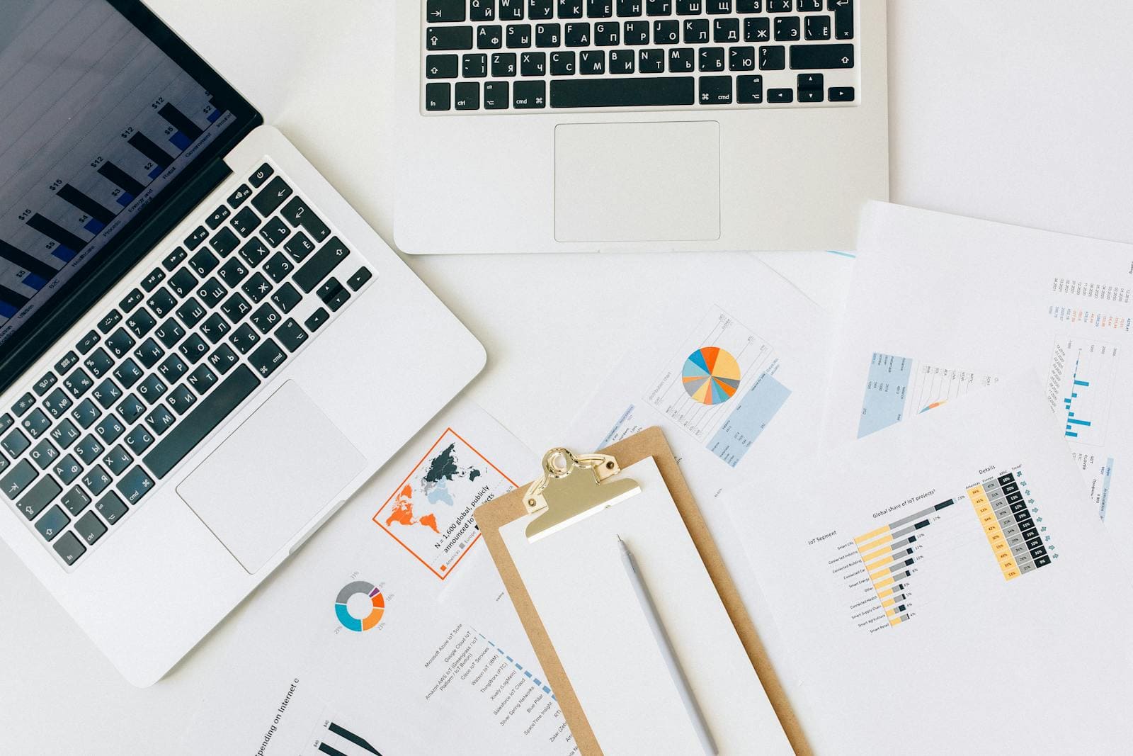 Overhead view of laptops, charts, and reports used for data analysis on a desk. Maximizing ROI with Data Analytics