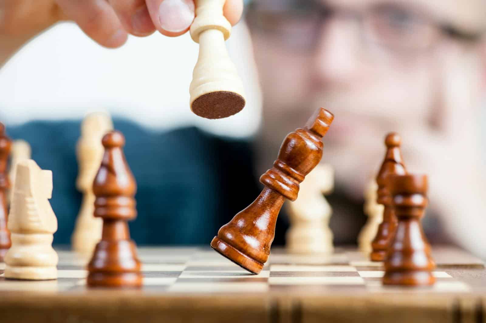 Empowering Decision-Making with Machine Learning Agents, Close-up of a chess game with a focused player, emphasizing strategy and competition.