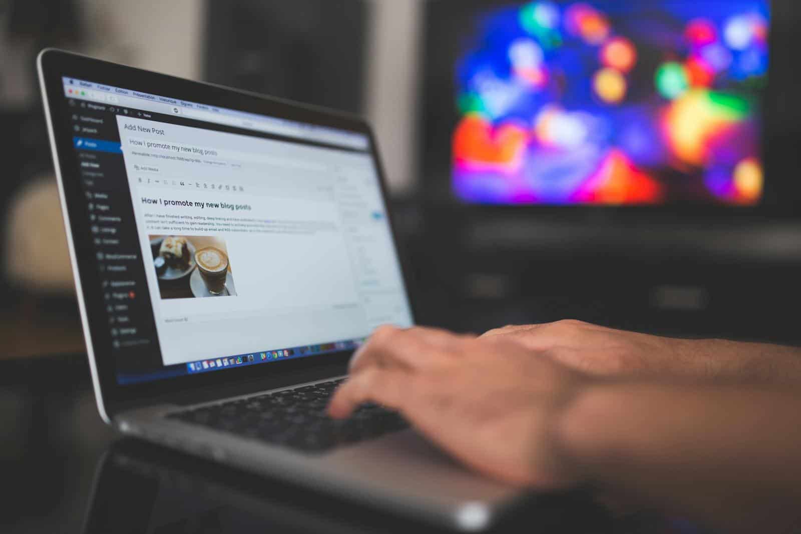 Content Generation, WP Autoblog, Content Generation, Content Promotion, Missinglettr, Publer, Newsletter, automation, promotion, Hands typing on a laptop with a blog post visible, cozy indoor setting with colorful screen in background.