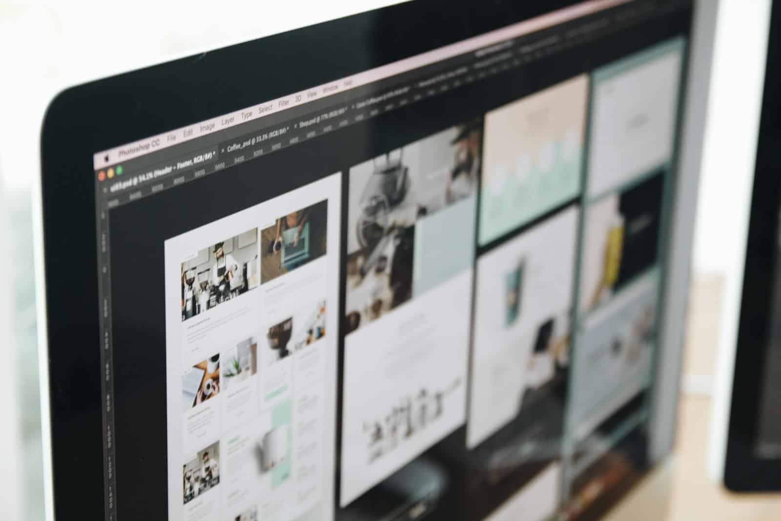 Website Hosting, A modern computer screen displaying web design work, showcasing creative visuals in a workspace.