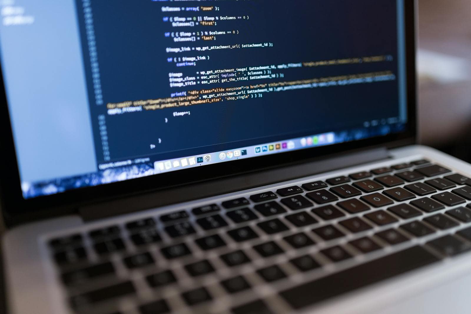 Wordpress development, Website, Plugins, Custom Content types,Managed WordPress Hosting, Website Security, Website Speed, Focused view of programming code displayed on a laptop, ideal for tech and coding themes.