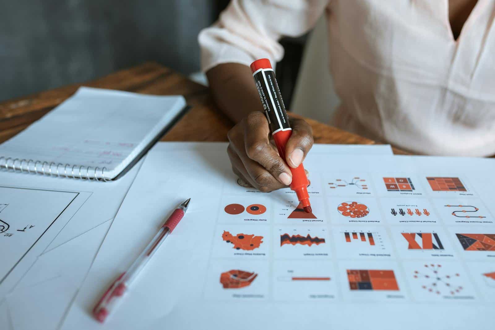 Taxonomies, development, information architechture, website, archive, cutomr post types, Jet Engine, Crocoblocks, management, e-Commerce, store, Close-up of a person marking business charts with a red marker, showcasing data analysis and planning.