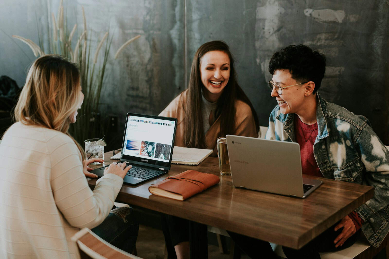 three people sitting in front of table laughing together. Lifetime subscribtion, lifetime deal, subscription fatigue, small business, productivity tools