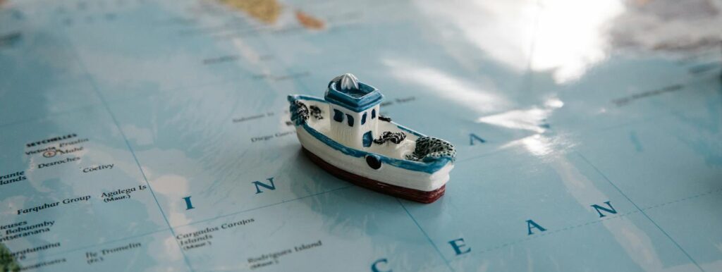 Close-up of a toy ship placed on a map of the Indian Ocean, evoking travel and exploration themes.