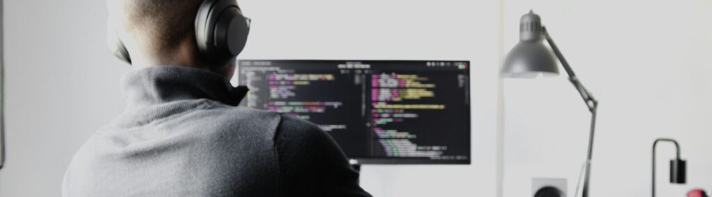man in black long sleeve shirt wearing black headphones sitting on chair