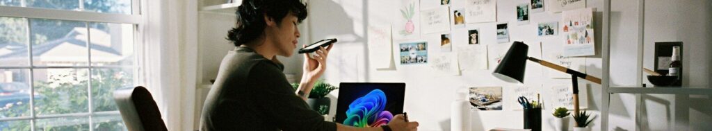 Person working at desk with laptop and phone.