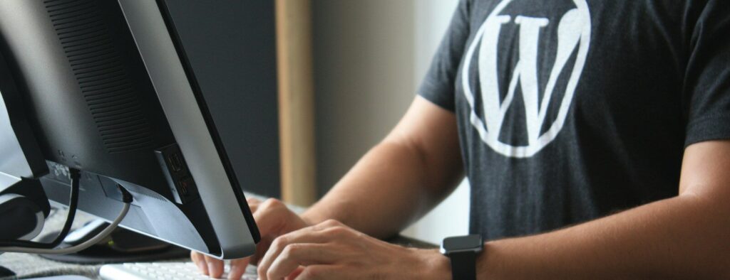person in black and white t-shirt using computer